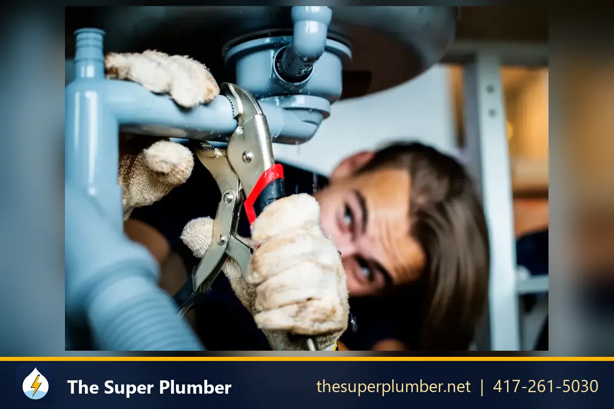 Plumber tightening an under-sink drain with locking pliers - plumbing service areas