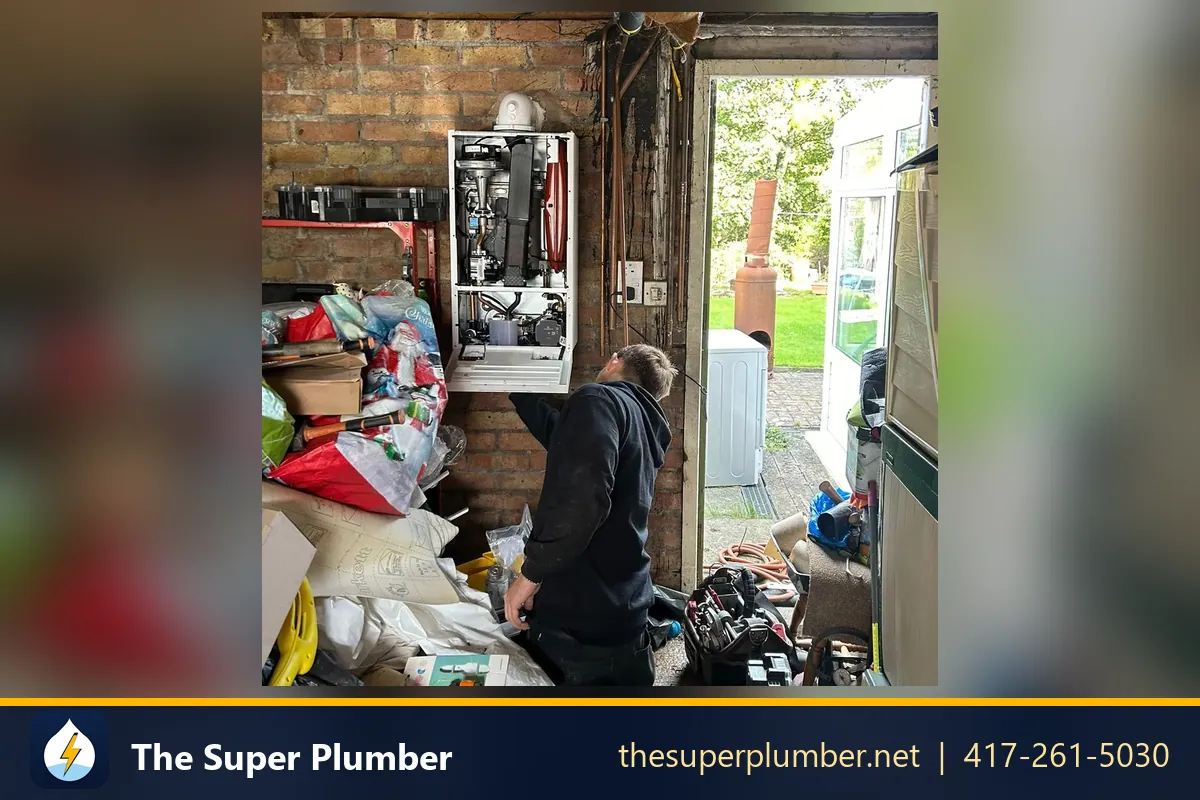 Technician servicing a wall-mounted tankless water heater in a garage - electric tankless water heater