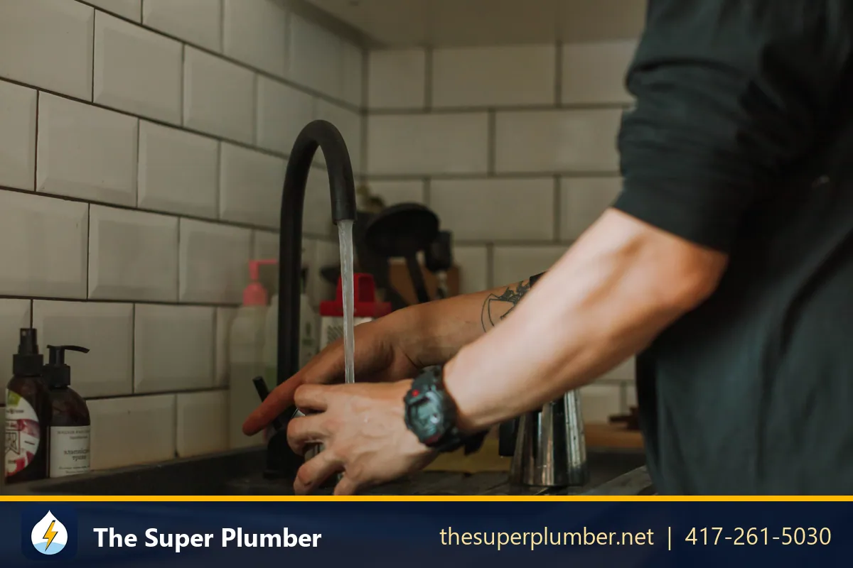 Hands adjusting a black gooseneck kitchen faucet - how to install a kitchen faucet