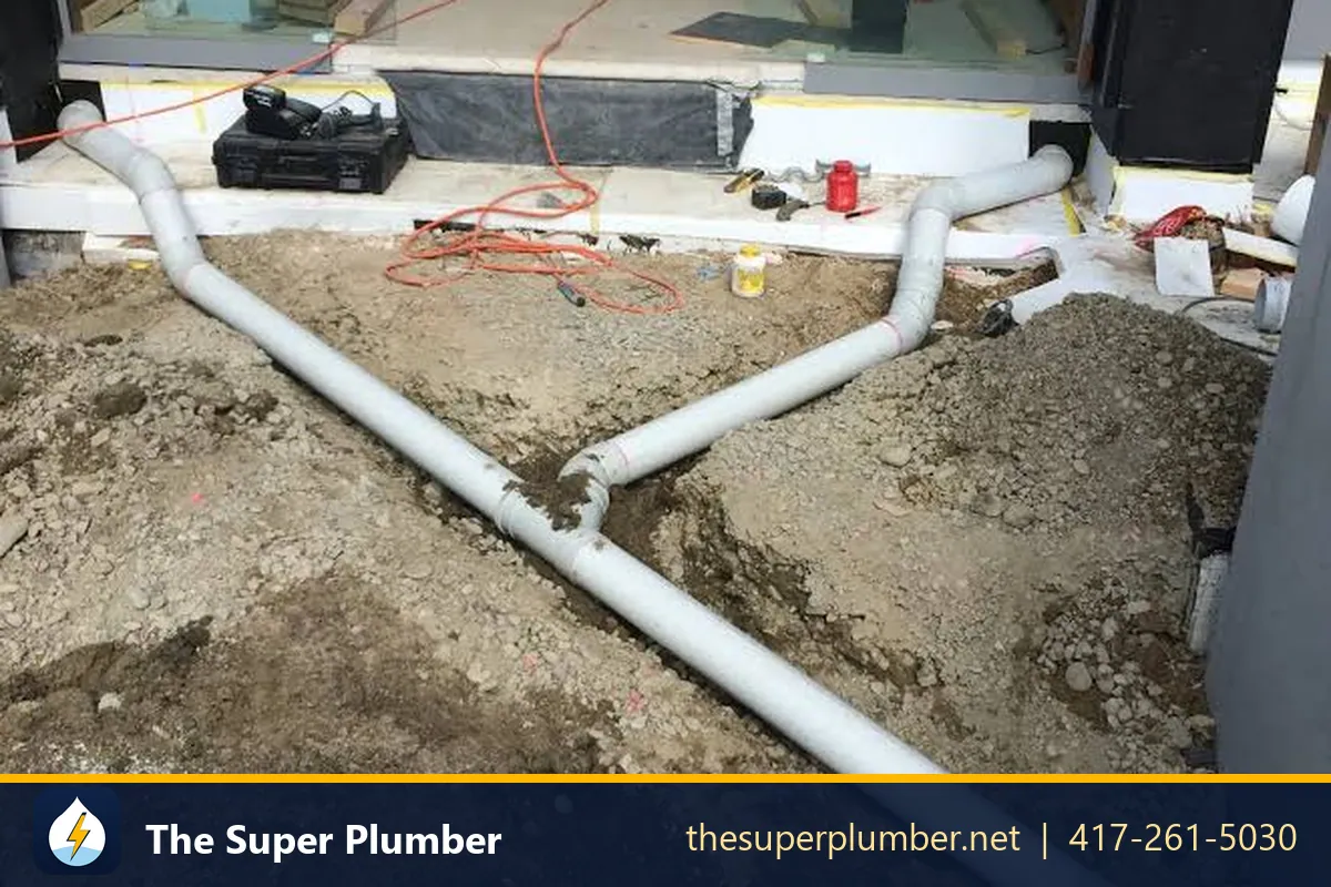 White PVC pipes laid in soil below a floor before the concrete slab is poured - plumbing replacement
