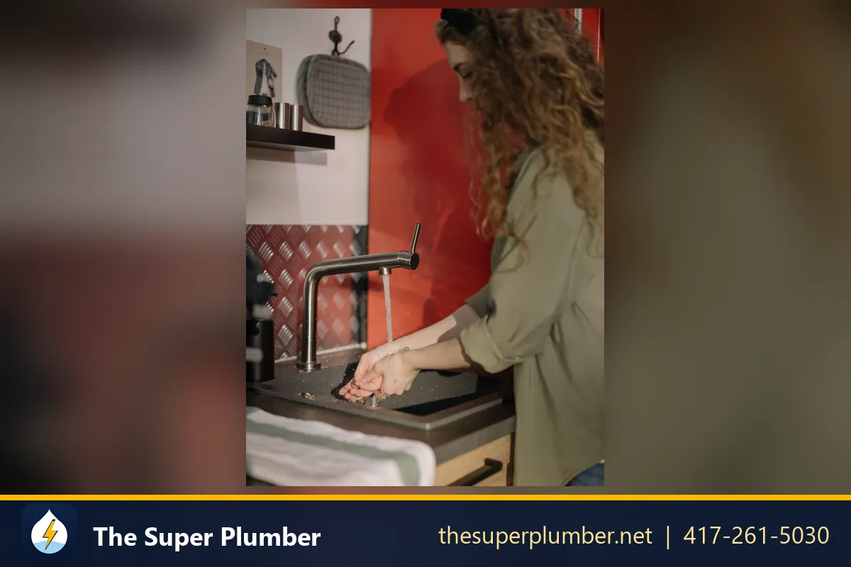 Woman rinsing her hands under a steady flow from a kitchen faucet - refrigerator water line